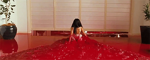 Mitsuko se desliza por el salón de su casa, convertido en una piscina de sangre. Imagen obtenida aquí.  