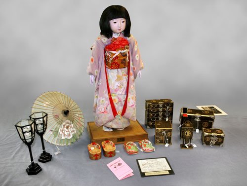 Miss Mie junto a algunos de sus accesorios, un ejemplar original de Torei-ningyô.