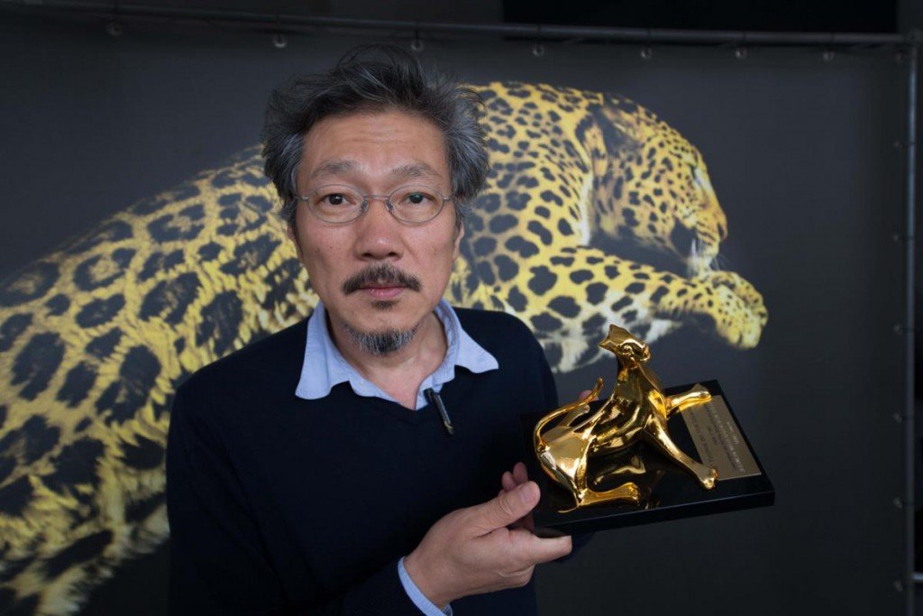 Imagen del director de la cinta, Hong Sang-soo, posando junto al Leopardo de Oro en el Festival de Locarno de 2015.