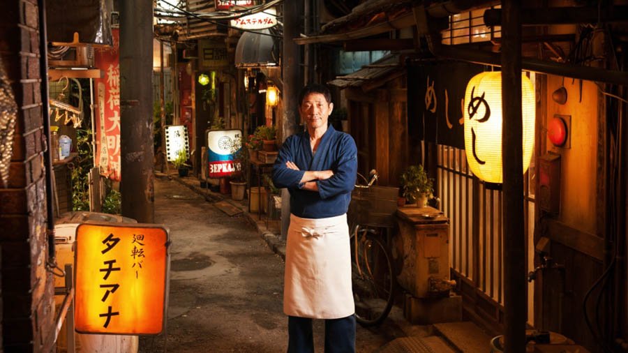 El oscuro callejón de Shinjuku en el que se encuentra el restaurante. En el centro, su gerente y cocinero, "El maestro".